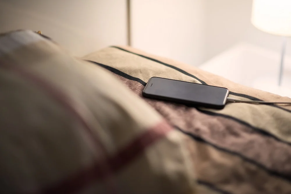 Overnight charging phone on nightstand with clock myths